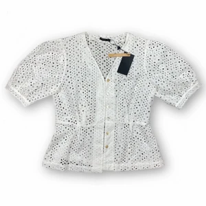 Topp - Supersöt button up blus från STOCKH LM, storlek 42. Ny med prislapp kvar! Orginalpriset har varit 599kr. Puffiga ärmar. Mått -  Ärmlängd 34cm, axel till axel 39cm, midjebredd 43cm. 