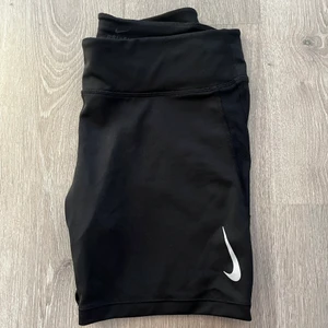 Nike högmidjade Dri-fit shorts - Nike högmidjade Dri-fit shorts i storlek L.  Nästan aldrig använda. Är genomskinlig på varsin sida (vänligen se bild 2), dragkedja finns bak och snören finns på insidan.  Kan skickas spårbart med Postnord för 51 kr eller hämtas upp i Ludvika.