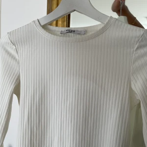 Vit topp (öppen rygg - Säljer denna långarmade topp från Nakd, använd en gång!  kan mötas upp i Stockholm annars står köparen för frakten