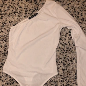 Vit tröja från Boohoo  - Vit enärmad tröja från boohoo i storlek 36. Tröjan är i mycket bra skick och ändast använd fåtal gånger. Tröjan är heller inte genomskinlig, som den ser ut att vara på första bilden. 