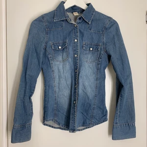 Jeansskjorta  - Jeansskjorta ifrån Ginatricot, storlek 32 passar även en  34. Köparen står för frakten 