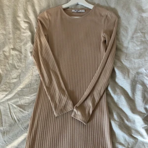 Nakd klänning - Beige klänning från NAKD. Lång med liten slits på sidan. Endast använd en gång.