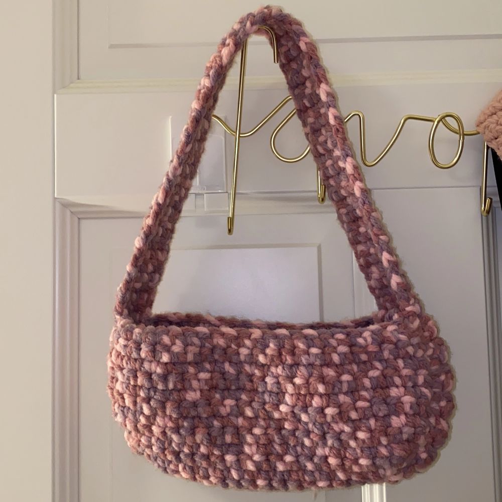 En handgjord virkad shoulderbag men rosa och lila mönster. Den är aldrig använd och väldigt unik. Jag står för frakten så om ni är intresserade är det bara att skriva till mig. Självaste väskan är 27x13 cm lång.. Väskor.