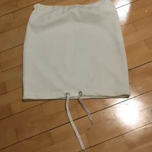 Vit kjol med snörning nedtill - Vid kjol med resår i midjan och snörning nedtill