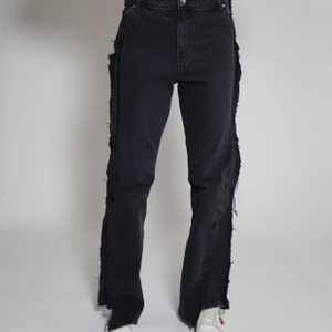 Black frayed jeans - Högmidjade jeans i boyfriend modell. Rå kant med fransar som revär på sidorna. Ursprungligen H&M jeans som är omgjorda av Scannable UF. Genom att skanna en QR-kod som finns fäst på plagget kan du läsa mer om materialet och dess miljöpåverkan!