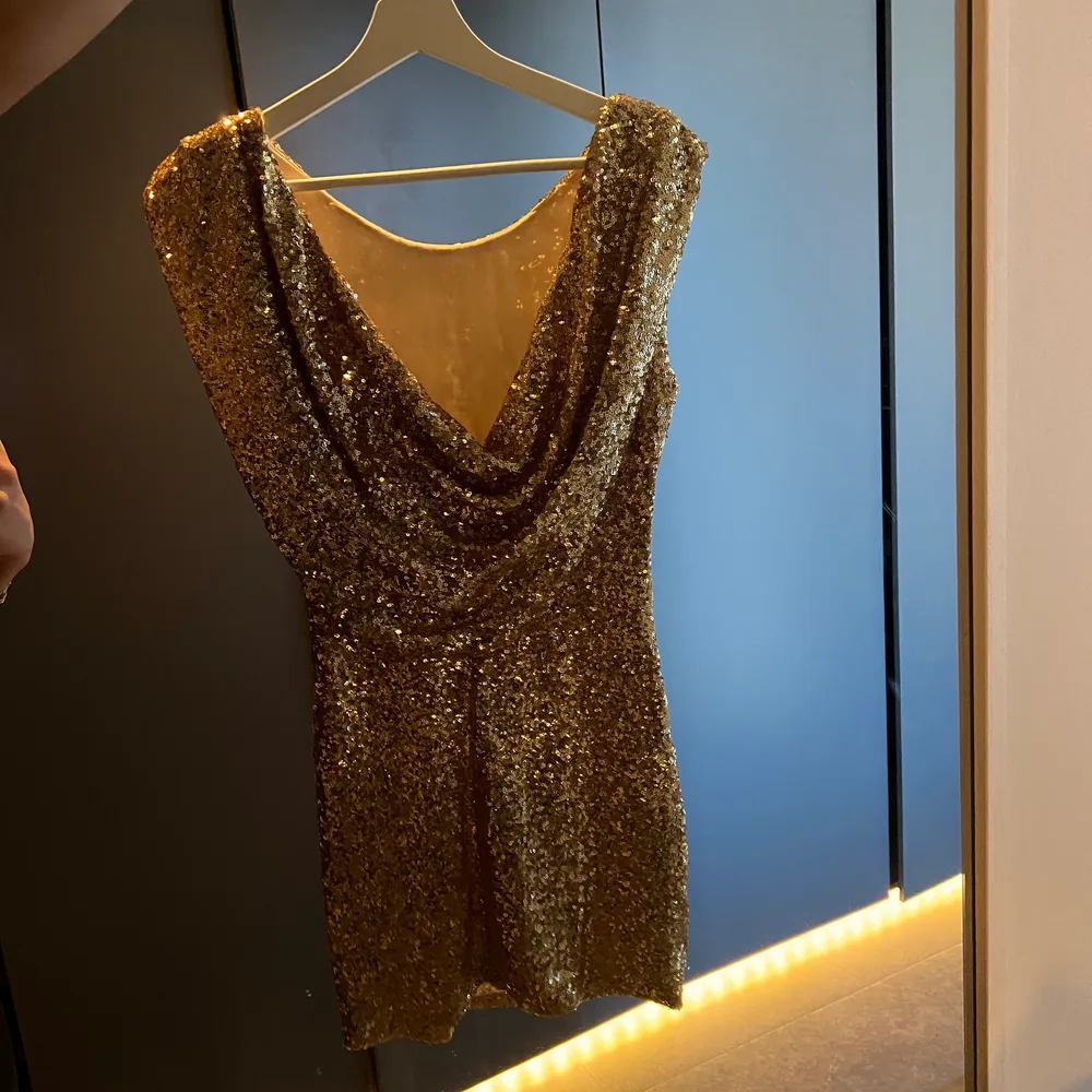 Drömklänning i guldiga paljetter😍  Den går att ha åt båda hållen, både med vattenfallsringning fram och bak i ryggen! . Klänningar.