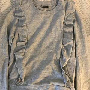 Volang sweatshirt - En super fin grå sweatshirt med volanger på! Så fin verkligen och passar med mycket! I jätte bra skick, köpt second hand men endast använd utav mig Max 3 ggr! Det är bara att komma privat vid frågor eller om du vill ha fler bilder!🥰