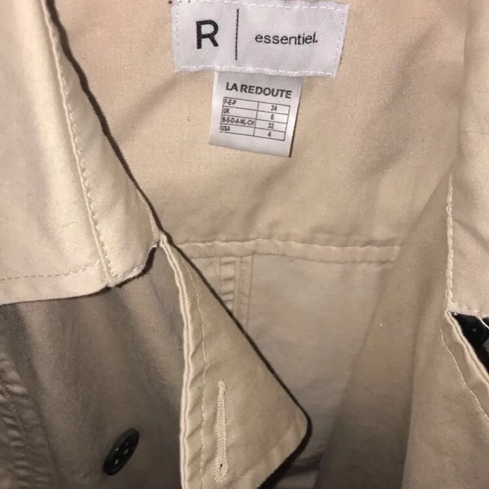 Beige midjelång trenchcoat i storlek 34. Jackor.