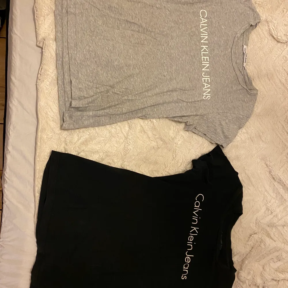 En ljusgrå och en svart t-shirt från Calvin Klein. Den ljusgrå är i storlek S och den svarta i storlek XS. Den svarta har några små hål i framsidan men inget man märker så mycket. . T-shirts.