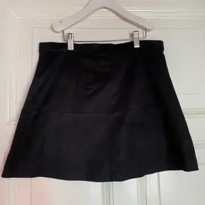 En superfin kortare svart kjol i mocka material, silvrig dragkedja på baksidan (går ner till hälften). Storlek S, passar dock inte riktigt mig som normalt har XS/S i kjolar💌