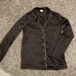 Pyjamas skjorta - En pyjamas skjorta från Gina Tricot och är i princip aldrig använd. Svart med rosa detaljer och är i silkes material. Storlek XS men passar S också. Köpare står för frakt.