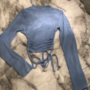 Långärmad tröja från boohoo - En ljusblå långärmad tröja med öppen rygg och knytning från boohoo i storlek 36, köparen står för frakten! 💕