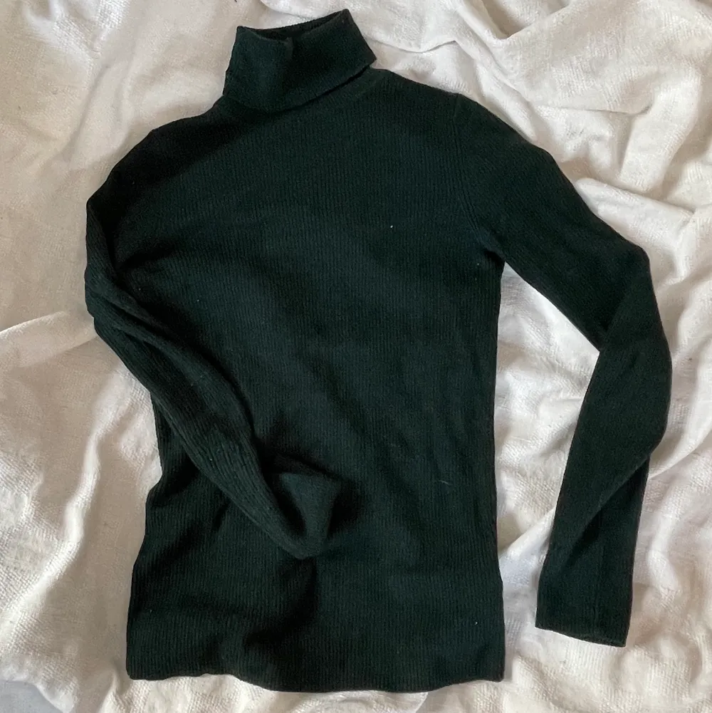 Mörkgrön turtleneck som är ribbat stickad och mycket stretchig. Svårt att visa färgen exakt på bilderna men bild 2 är mest lik verkligheten. Passar academiastilen men är även en superbra basic att ha i garderoben. 100% ull så toppen för lager på lager nu i vintern. . Toppar.