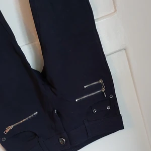 Mörkblå byxor stl. Xs - Mörkblå stretchiga byxor med silverdetaljer xs. För mer info, kom privat. I priset ingår inte frakten!