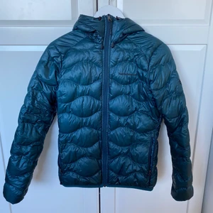 Peak Performance Helium Hood Jacket - Peak Performance jacka i en jättefin blå/grön färg i stolek M. Jackan har tyvärr hål på den vänstra ärmen vilket dock inte syns när den bärs då det är på innersidan av ärmen! Nypris för jackan är 2400kr men säljs för 900kr! Priset kan dock diskuteras!