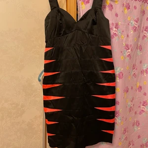 Festklänning - Snygg svart festklänning med orange detaljer från HM. Storlek 38. Hund finns i hemmet!