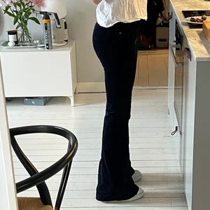 Manchesterbyxor flare mörkblå 36 - Mörkblå flare manchesterbyxor från Crocker. väldigt utsvängda men tight fit över ben och låg midja, jättesnygg passform och fint skick! Storlek 28/35 men liten i midjan så mer som en 26 och uppsydda till 33, går att sprätta upp ifall man vill ha längre. Jag är 166cm och har Alexander Mcqueen chunky sneakers med platform på bilderna för referens.