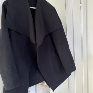 Svart kappa - Säljer denna tunna svarta kappa. Den saknar ett skärp fungerar fortfarande som en snygg blazer. Finns inga hål eller fläckar.
