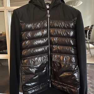 Moncler cardigan (som ny) - Säljer en Moncler Cardigan somn knappt är använd. Inköpt på NK i våras. Kvitto finns om önskas. Skicket är som helt ny knappt använd. Säljer pga för stor.  Nypris: 8000 kr
