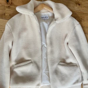 Beige teddyjacka från NA-KD - Beige teddyjacka från NA-KD! Supermysig nu till hösten och vintern🫶säljer då den inte kommer till användning. Strl 34 men skulle säga att den är som en 36-38.
