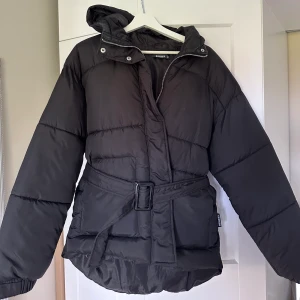 Vinterjacka med bälte  - Säljer min fina dunjacka med bälte i midjan från missguided, köpt förra året men kom knappt till användning så mycket bra skick! Frakt tillkommer