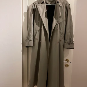 Trenchcoat med fodring - Retro Trenchcoat med avtagbar fodring av äkta mink. Jag köpte den på tradera men tyvärr passa den inte mig så jag får ta och sälja den vidare till någon annan. Den är väldigt fin och av bra kvalitet. Den är från mycket äldre dar därav retro