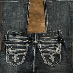 Lågmidjade bootcut Rock Revival jeans - Säljer dessa svinsnygga lågmidjade bootcutjeansen från Rock Revival. Storlek: 29 💗midjemått: 86,5 cm💗innerbenslängd: 76 cm 🖤 Nypris på rock revival jeans är 1800kr 🖤frakt: 69kr 