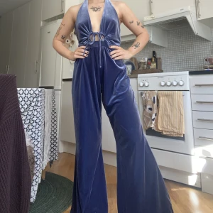 Jumpsuit - Jumpsuit i velvet från Urban Outfitters. Använd 1 gång, storlek S! Superfin blå/lila färg, med knytning framtill och öppen rygg. Skriv till mig vid intresse 🙌