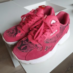 Adidas sneakers - Använda men fortfarande i gott skick! Som ni ser på bilderna kan färgen se lite olika ut i olika ljus, men skulle beskriva färgen vara röd/rosa ☺️