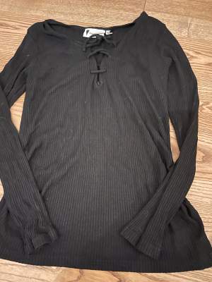 En fin svart tröja med snören vid bröstet, stretchig och enkel att styla, pris kan alltid diskuteras