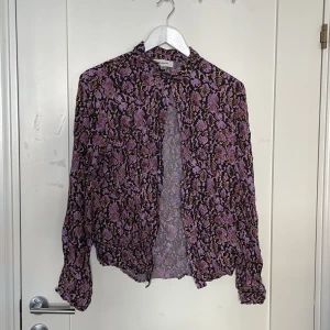 Lila skjorta - Lila skjorta med ”orm mönster”. Skulle säga att den är mer i M än L.  Den har knappar längs hela framsidan men orkade tyvärr inte knäppa alla❤️