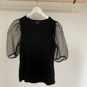 Svart blus med puffärm - Aldrig använd topp med puffärm infrån Gina Tricot, storlek L, men liten i storleken, är själv S/M