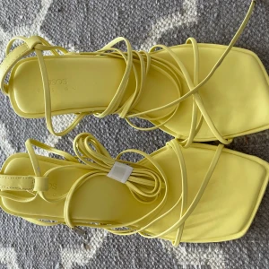 Gula klackar med snörning - Pastell gula klackar med lång snörning💛Endast provade en gång. De är lite skadade på ena skon (bild 3). Annars i fint skick. 