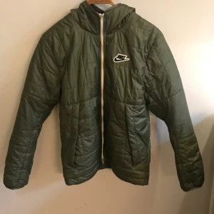 Nike höst/vårjacka - Fodrad med fleece.  Endast använd en höst Lite sliten på ena ärmen men det syns inte eftersom det är på insidan, se bild.  Lite mörkare på tyget längst ner vid ärmslutet Nypris cirka 1000kr