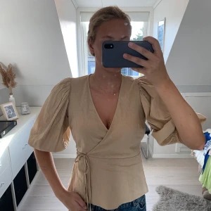Blus i linne - Beige blus med knyte i äkta linne-material. Så fin men tyvärr för liten! (Frakt tillkommer) 