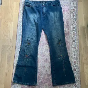 suuupersnygga lågmidjade utsvängda jeans med paljett/pärldetaljer på benen. En liten slitning längst ner på ena benet men annars är det så gott som nya. Stl 36!