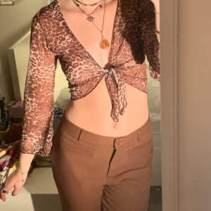 Topp - Leopardmönstrad meshtopp som man knyter där fram. Fina utsvängda ärmar.