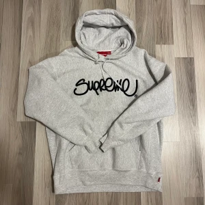 Supreme hoodie (Raised Handstyle Hooded Sweatshirt) - Köpt under Supremes drop under mars 2022 på deras hemsida. I princip ny, bara använd någon enstaka gång. Köpt för runt 1500kr. Supreme box logo sticker ingår vid köp! Storlek Medium, true to size.