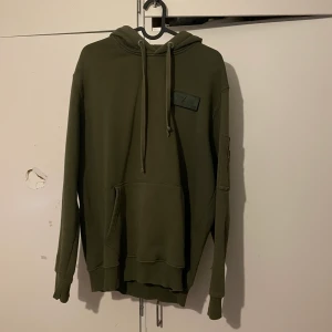 Alpha industries Hoodie - Säljer av lite kläder från garderoben. Denna har några är på nacken men är o gott skick inga tydliga deffekter.  Storlek L med passar även M.  Skriv gärna för fler bilder eller frågor