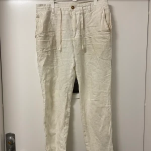 Ljusbeigea Linnebyxor - Säljer nu dessa ljusbeigea linnebyxor som är köpta på Mango. Byxorna är i storlek 40 och i ganska bra skick, de är lite fläckiga men går säkert att få bort. Relativt små i storleken, passar mig som har 38 vanligtvis men något korta.  
