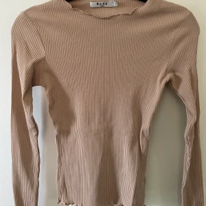 Ribbad tröja i beige  - Beige ribbad tröja från NA-KD i storlek S. Aldrig använd. 