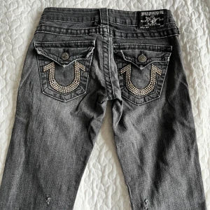 Lågmidjade True Religion jeans - Säljer mina absoluta favorit jeans!! De är lågmidjade och har supercoola detaljer vid fickorna! Skriv till mig för frågor eller fler bilder! (De har dock två små hål vid låren men det är inget man ser!)(Säljer två par till!!💗💗)