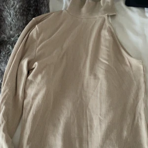 Tröja med en arm - Fin beige tröja med krage och en arm den är från bikbok och är i väldigt bra skick hör av dig om du vill ha fler bilder. köparen står för frakten ☺️