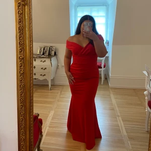 Röd långklänning - Den perfekta långa, röda klänningen. Passar vid tex bal. Materialet är stretchigt. Man kan göra klänningen lite ”off shoulder”. Klänningen markerar midjan fint och övriga delar av kroppen då den har lite ”mermaid” modell. Köparen står för frakten🤍
