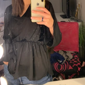 Svart fintröja i satin - Svart festlig tröja i satin, använd fåtal gånger och är i bra skick, väldigt bekväm!