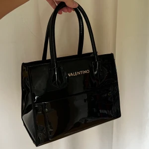 Valentino väska i latex  - Säljer min otroligt snygga valentino väska. Den är lite sliten på handtagen och kanterna (kan skicka bild) men i övrigt bra skick.  Nypris ca 2500kr. Mitt pris 300kr + frakt. 