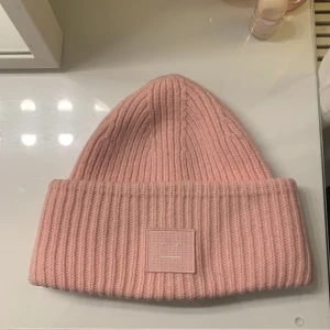 Rosa Acne mössa - Jag säljer min rosa acne mössa för att den inte har kommit till användning på sistone. Jag säljer den för 600 då nypris är 1500 och den är i ganska gott skick priset går att diskutera skriv för mer bilder.
