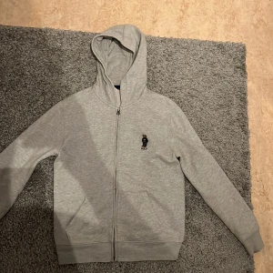 Polo Ralph Lauren Hoodie - Köpt för 1 år sedan på nk och är använd ca 10 gånger. Så skicket på tröjan är som ny, inga håller eller fläckar. Riktig skön tröja som passar perfekt under både vinter såsom sommar. 