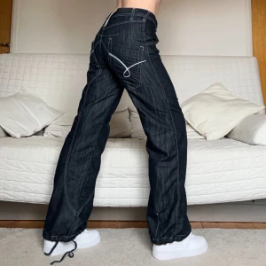 Baggy Jeans - Säljer dessa coola jeans med detaljer på bakfickorna och möjlighet att dra åt vid fötterna i storlek W28L34❤️81cm midja och 80cm innerbenslängd🥰Jag på bilderna är 172cm lång och brukar bära storlek 38🫶