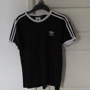 ADIDAS  - Svart och vit Adidas t-shirt som är i rätt bra skick, Ordinarie pris: 300kr